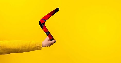 boomerang in female hand over yellow background, panoramic mock-up with space fo