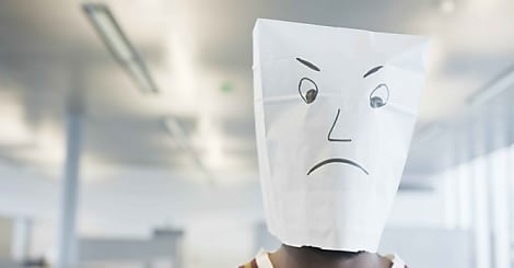 Businessman wearing a paper bag of sad face