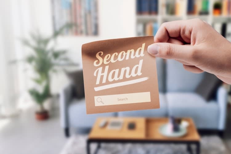 Woman holding a sticky note with 'Second Hand' text and search bar, she is promo