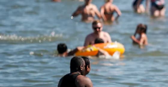 Des baigneurs à Chestermere, en Alberta, durant la dernière vague de chaleur dans l'Ouest canadien. LA PRESSE CANADIENNE/Jeff McIntosh