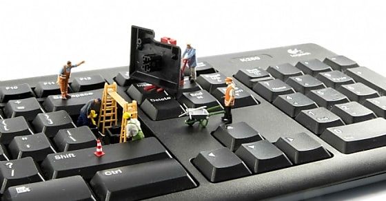 little world figures repairing the key board of the computer or try to hack or i